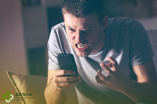 Мужчина раздражается на телефон